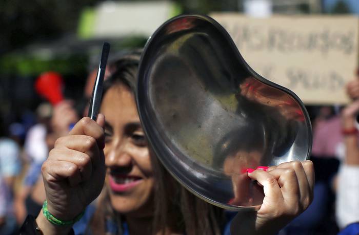 Una manifestante del sector de la salud, marcha en Santiago en el sexto día consecutivo de violencia callejera. · Foto: Pablo Vera, AFP