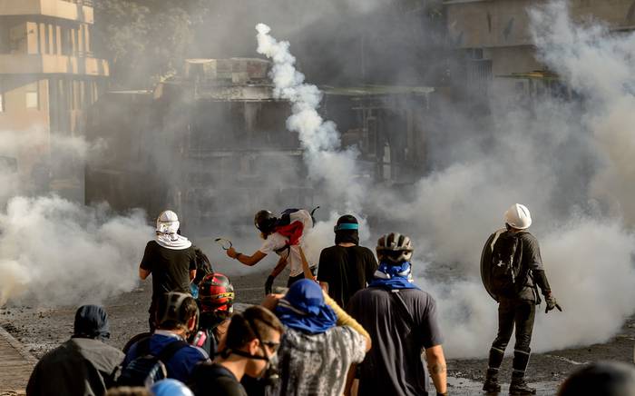 Manifestantes se enfrentan con la policía antidisturbios, durante una protesta contra el gobierno del presidente Sebastián Piñera, el viernes, en Santiago de Chile.  · Foto: Martín Bernetti, AFP