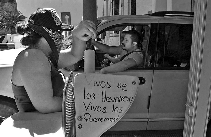  Mujeres con el rostro cubierto, compañeras de los estudiantes desaparecidos en Guerrero, toman puestos de peaje en la autopista que conduce al puerto turístico de Acapulco (México). / Foto: Francisca Meza, Efe.