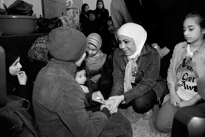 Al Shammat (c), ministra siria de Asuntos Sociales, con recién llegados del campamento de Al Yarmuk,
en un refugio improvisado en el centro de Damasco. Foto: Motaz Mawed, Efe