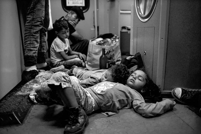 Familias migrantes duermen en el suelo de un tren que va de Budapest a Múnich, el martes. Foto: Vladimir Simicek, Afp