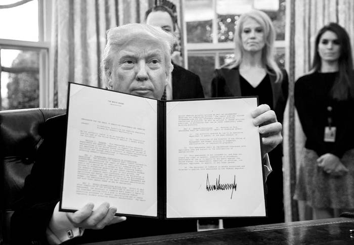 Donald Trump muestra una de las órdenes ejecutivas que firmó, ayer, en la Oficina Oval de la Casa Blanca. Foto: Nicholas Kamm, AFP