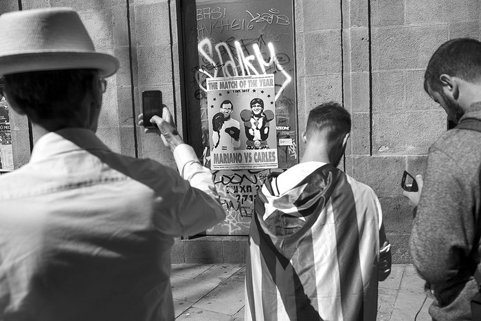 Un afiche muestra al presidente español, Mariano Rajoy, y al presidente del Gobierno de Cataluña, Carles Puigdemont, el sábado, en Barcelona. Foto: Josep Lago, AFP