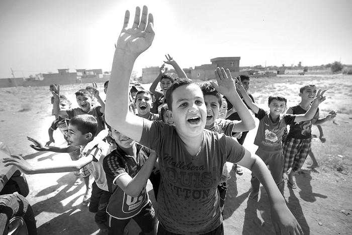 Los niños iraquíes saludan al Ejército, a su llegada al primer barrio en las afueras del sur de Kirkuk, ayer, durante una operación contra combatientes kurdos. Foto: Ahmad Al-Rubaye, AFP