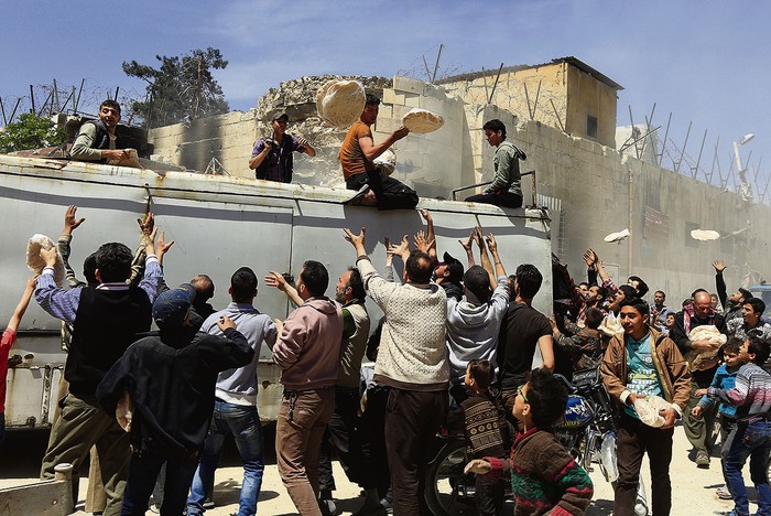 Reparto de pan donado por el gobierno, ayer, en las afueras de Damasco, Siria.
 · Foto: Louai Beshara