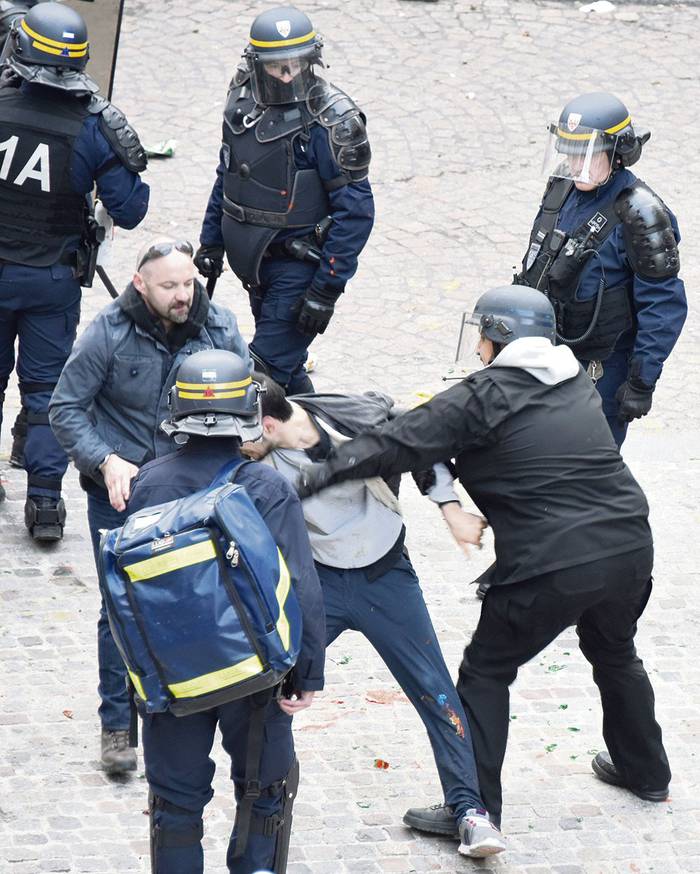 El jefe de seguridad del Elysee, Alexandre Benalla (cent.), al lado de Vincent Crase (cent., izq), asistente de seguridad, mientras arrastran a un manifestante, el 1 de mayo durante las protestas en París.
 · Foto: Naguib-Michel Sidhom