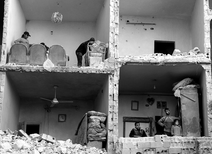 Ciudadanos sirios en un edificio dañado en la ciudad de Alepo, en el norte de Siria, el domingo. Foto: Karam Al Masri, Afp