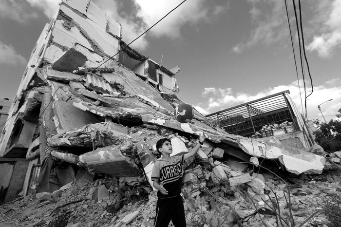 Un niño palestino juega al fútbol al lado de los restos de su casa, destruida por Israel en el verano de 2014, ayer, en la ciudad de Gaza. Foto: Mahmud Hams, Efe