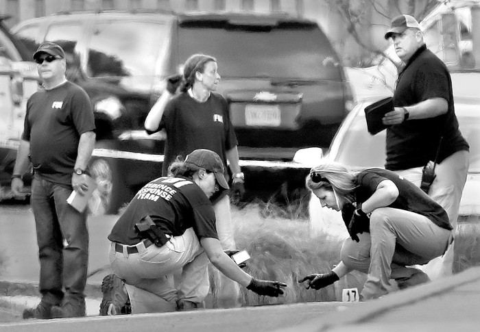 Investigadores buscan evidencias en un estacionamiento del campo de Eugene Simpson, en Alexandria, Virginia. Foto: Win Mcnamee, AFP