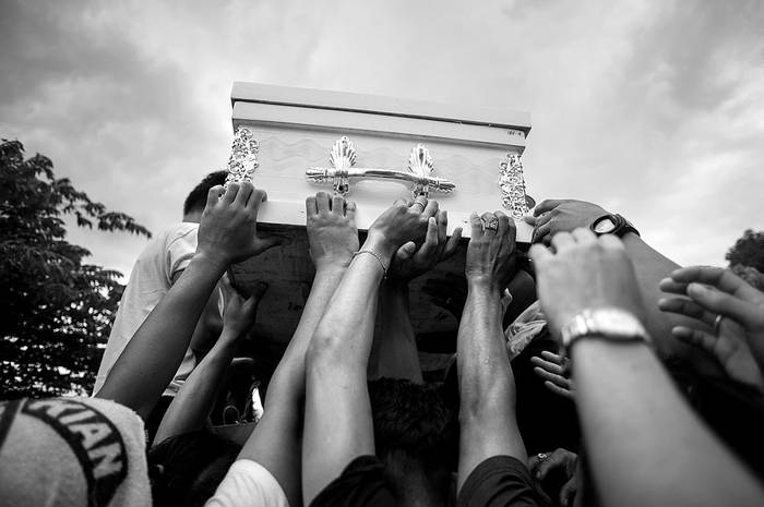 Familiares de Kian Delos Santos, un estudiante de 17 años asesinado presuntamente por agentes de la Policía, durante el entierro, el sábado, en un cementerio en Manila. Foto: Noel Celis, AFP