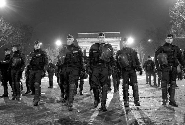 Policías franceses patrullan en los Campos Elíseos en París, la madrugada del sábado, durante las celebraciones por la llegada de un nuevo año. · Foto: Efe, Lucas Dolega