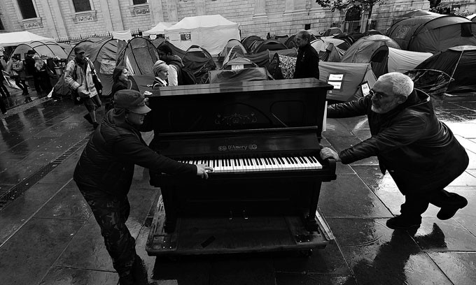 Manifestantes anticapitalistas mueven un piano que les donaron hacia el campamento de los indignados en los alrededores
de la Catedral de Saint Paul, el miercoles 26 de octubre en Londres.  · Foto: Efe, Andy Rain