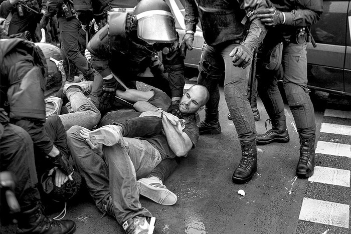 Agentes de policía españoles y adherentes al referéndum, fuera de la mesa de votación de Ramón Llull, en Barcelona. Foto: Fabio Bucciarelli, AFP
