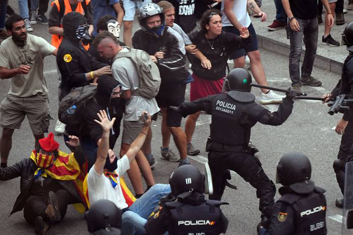Manifestantes se enfrentan con policías españoles frente al aeropuerto de El Prat, en Barcelona. · Foto: Lluis Gene, AFP