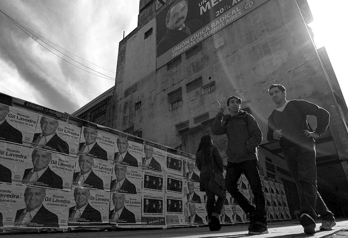 Transeúntes junto a carteles electorales en las calles de Buenos Aires.  · Foto: David Fernández, Efe