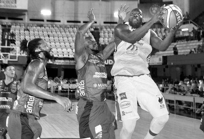 TJ Cummings y Kenny Adeleke, de Goes, y Anthony Johnson, de Atenas, el martes en el Palacio Peñarol. Foto: Javier Calvelo