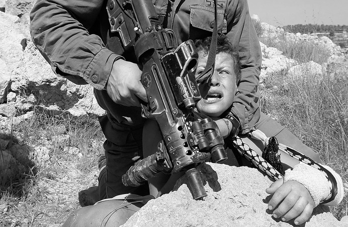 Un soldado israelí controla a un niño palestino luego de una marcha en contra de la confiscación de tierras palestinas,
en Nabi Saleh, cerca de Ramala. Foto: Abbas Momani, Afp (archivo, agosto de 2015)