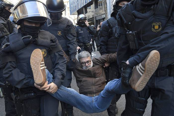 Policías llevan al diputado regional catalán Carles Riera, de Candidatura de la Unidad Popular (CUP), durante una manifestación para protestar contra el juicio de ex líderes separatistas catalanes, ayer, en Barcelona. · Foto: Lluis Gene