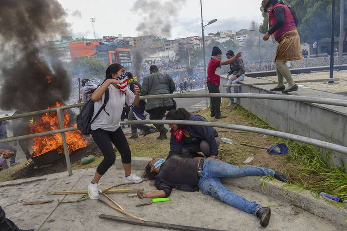 Enfrentamiento  de manifestantes con la policía antidisturbios, ayer, fuera de la asamblea nacional, en Quito. · Foto: Martín Bernetti, AFP