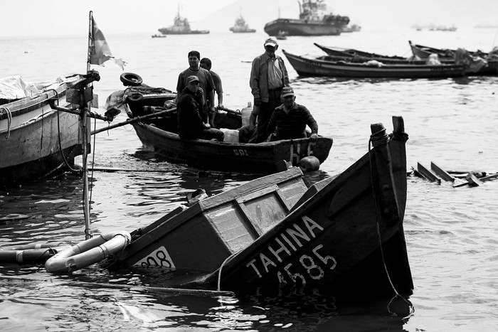 Varios pescadores, ayer, en el puerto de Iquique (Chile), durante la búsqueda de otros botes tras el terremoto de 8,2 grados de magnitud que la noche del martes sacudió las regiones de Arica, Parinacota, Tarapacá y Antofagasta, en el norte de Chile. / Foto: Luis Hidalgo, Efe.