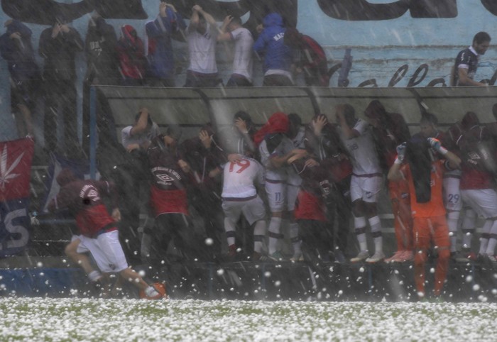 Jugadores e hinchas de Nacional durante la granizada que llevó a suspender el partido Liverpool-Nacional, el sábado, en el Estadio Belvedere. · Foto: Sandro Pereyra