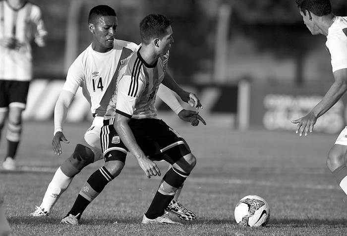 El argentino Tomás Martínez y el peruano Pedro Aquino, ayer, en el estadio Alberto Suppici, en Colonia. Foto: Nicolás Rodríguez, Efe