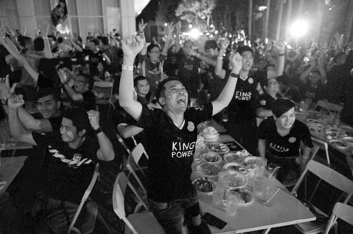 Hinchas tailandeses de Leicester festejan el triunfo de su equipo sobre Swansea. Leicester City es propiedad el mutimillonario tailandés Vichai Srivaddhanaprabha. Foto: Lillian Suwanrumpha, Afp