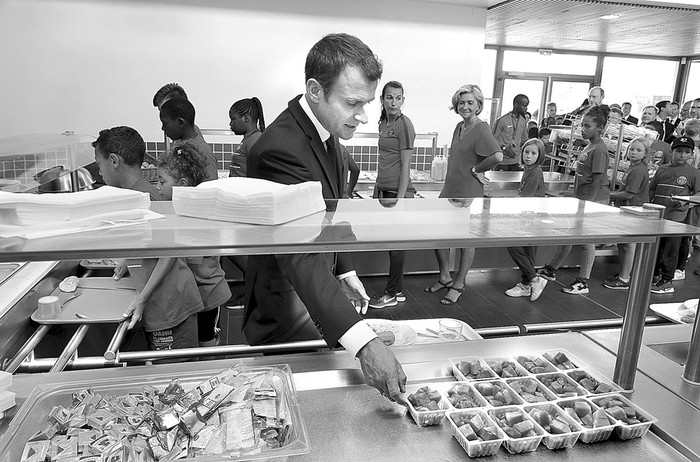 Emmanuel Macron, presidente francés, en un restaurante junto a niños de la Fundación Paris Saint-Germain, ayer, en Moisson. Foto: Philippe Wojazer, AFP