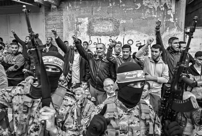 Palestinos e integrantes de las brigadas Ezzedine al Qassam durante una movilización por el 30º aniversario de Hamas, ayer, en la ciudad de Gaza. Foto: Said Khatib, Afp