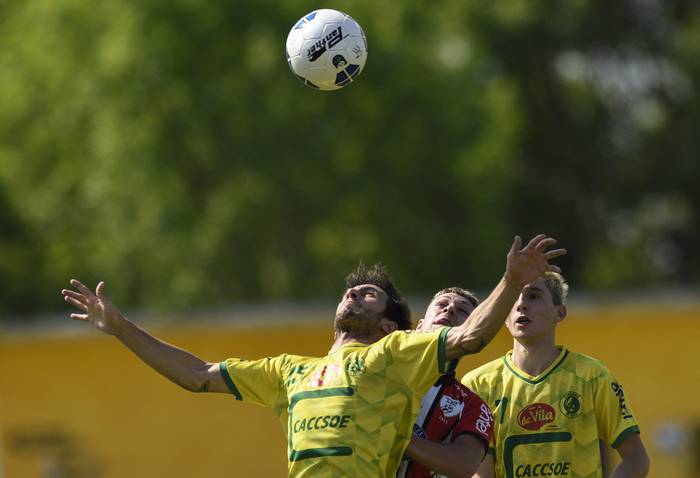 Bruno Alejandro Gómez, de Canelones del Este, Gustavo Alejandro Pintos, de Salto, y Omar Maximiliano Machín, de Canelones del Este, durante la primera final, en el Estadio del Club Progreso, en Estación Atlántida, Canelones.  · Foto: Fernando Morán