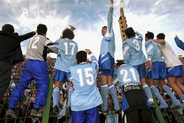 Los jugadores de la selección uruguaya festejan el título frente a la tribuna Olímpica, en el estadio Centenario, el 23 de julio de 1995. · Foto: David Leah, Mexsport, AFP
