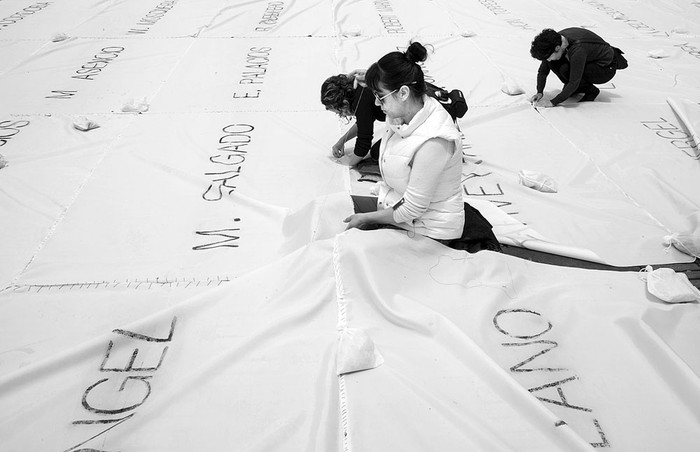 Instalación con los nombres de las víctimas del conflicto de Colombia pintados en cenizas, ayer en la plaza Bolívar de Bogotá. Foto: José Miguel Gómez, AFP