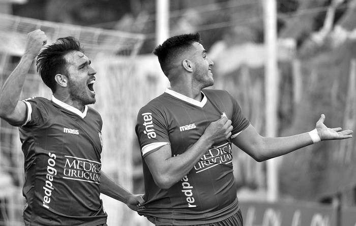 Maximiliano Gómez (d) y Matías Zunino festejan un gol de Defensor Sporting a Nacional, el sábado, en el estadio Luis Franzini. Foto: Federico Gutiérrez