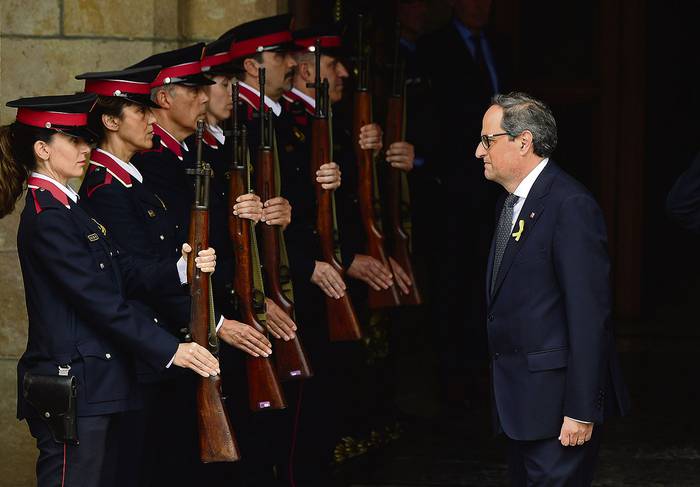 Oficiales de la policía catalana presentan armas al nuevo presidente regional electo de Cataluña, Quim Torra, ayer, en el Parlamento catalán.
 · Foto: Lluis Gene