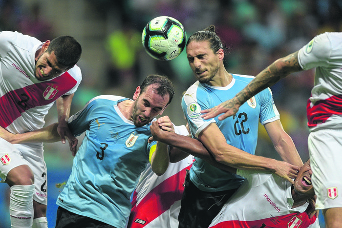 Luis Abram, de Perú, Diego Godín y Martín Cáceres, de Uruguay, en el estadio Arena Fonte Nova. (Archivo, junio 2019) · Foto: Juan Mabromata, AFP