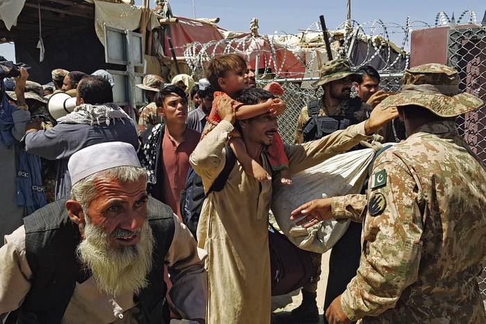 Soldados paquistaníes controlan a ciudadanos afganos en el cruce fronterizo entre Pakistán y Afganistán en Chaman el 13 de agosto de 2021, después de que los talibanes tomaran el control de la ciudad fronteriza afgana en una rápida ofensiva en todo el país. · Foto: Stringer, AFP