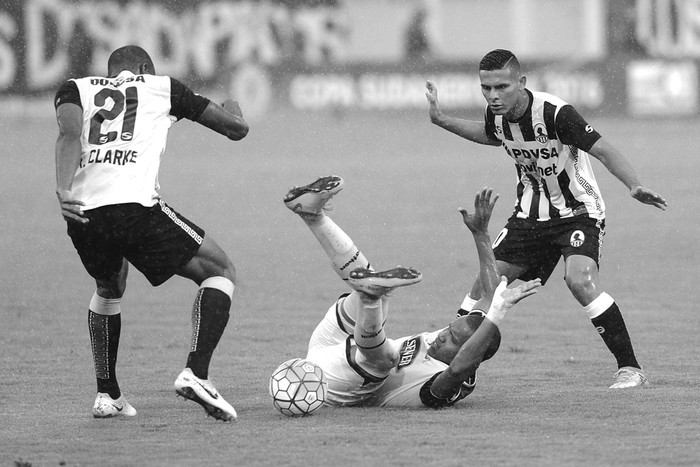 Ricardo Clarke y Pedro Ramírez, de Deportes Zamora de Venezuela, y Ely Esterilla, de Barcelona de Ecuador, por la Copa Sudamericana, en el estadio Agustín Tovar en Barinas, Venezuela. Foto: George Castellanos