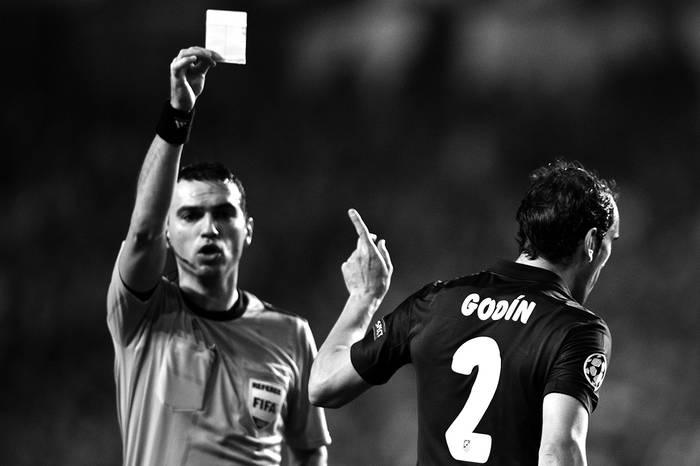 Diego Godín, de Atlético de Madrid, junto al árbitro Ovidiu Hategan, durante el encuentro con Benfica, ayer, en el Estadio de Luz, en Lisboa. Foto: Patrícia de Melo Moreira, Afp