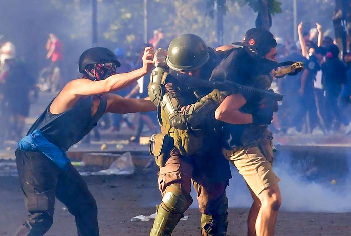 Enfrentamientos de manifestantes y policías antidisturbios, en Santiago de Chile. · Foto: Martin Bernetti / AFP