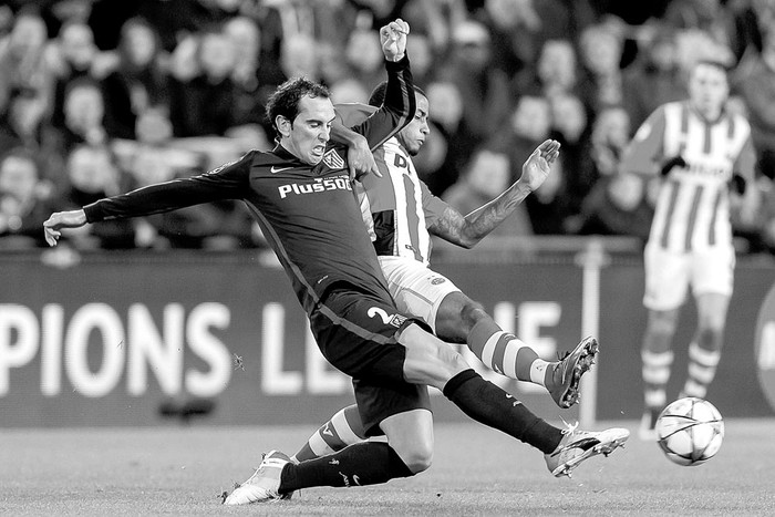 Diego Godín, de Atlético de Madrid, y Luciano Narsingh, del PSV, en partido por los octavos de final
de la Liga de Campeones, ayer, en Eindhoven, Holanda. Foto: Erwin Spek, Efe