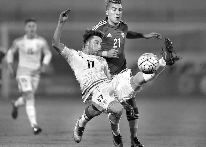 Matías Viña, de Uruguay, y Marcelo Torres, de Argentina, el sábado, en el estadio Olímpico, de Ibarra, Ecuador. Foto: Juan Cevallos, AFP