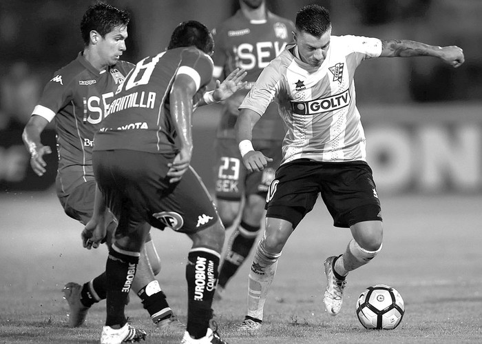 Jorge Rodríguez, de Cerro, y Dagoberto Currimilla, de Unión Española, de Chile, ayer, en el estadio Luis Tróccoli. Foto: Miguel Rojo, AFP