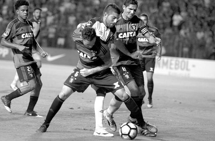 Giovanni Zarfino (c), de Danubio, entre Eugenio Mena (i) y Durval, de Sport Recife, ayer, en el estadio Adelmar da Costa Carvalho, en Recife, Brasil. Foto: Leo Caldas, AFP