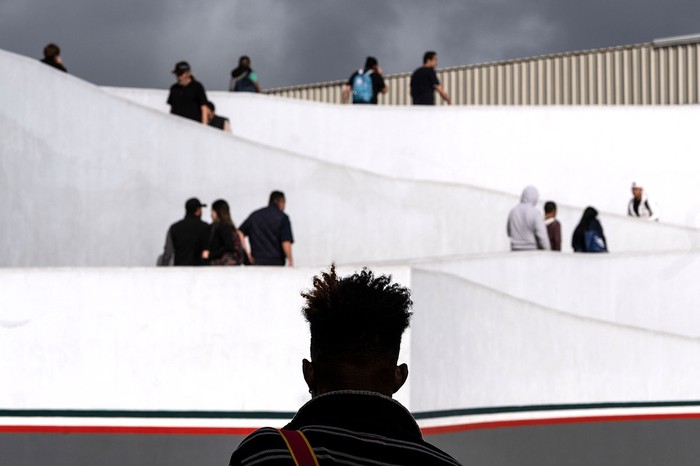 Solicitantes de asilo esperan en la entrada de El Chaparral, en Tijuana, estado de Baja California, para presentarse a las autoridades fronterizas de los Estados Unidos.
 · Foto: Guillermo Arias, AFP