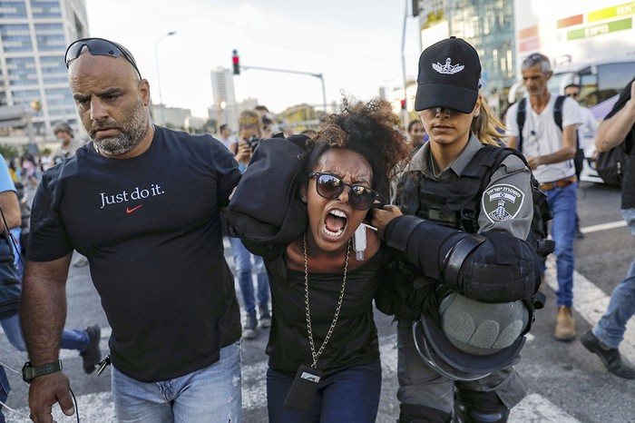 Fuerzas de seguridad israelíes detienen a una manifestante durante una protesta contra la violencia policial, ayer, en Tel Aviv.
 · Foto: Ahmad Gharabli, AFP