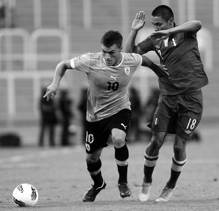 Renato César, de Uruguay, y Jean Deza Sánchez, de Perú, el domingo, durante el partido disputado en el estadio Malvinas Argentinas de la ciudad de Mendoza. · Foto:  Tresfotografia, Efe