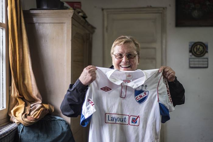 Lila Islas, ex futbolista y capitana del Club Nacional de Football en los 70, posa, en su casa del balneario Las Toscas, con la camiseta que le obsequió Joaquín Boghossian, la última vez que fue a ver a Nacional en el Parque Central. 

 · Foto: Natalia Rovira