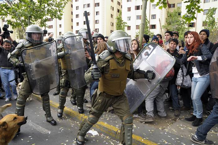 Carabineros y manifestantes durante las protestas de los estudiantes de enseñanza secundaria en Santiago de Chile. Foto: Andrés Bravo, Citizenside, Afp (archivo, octubre de 2014)