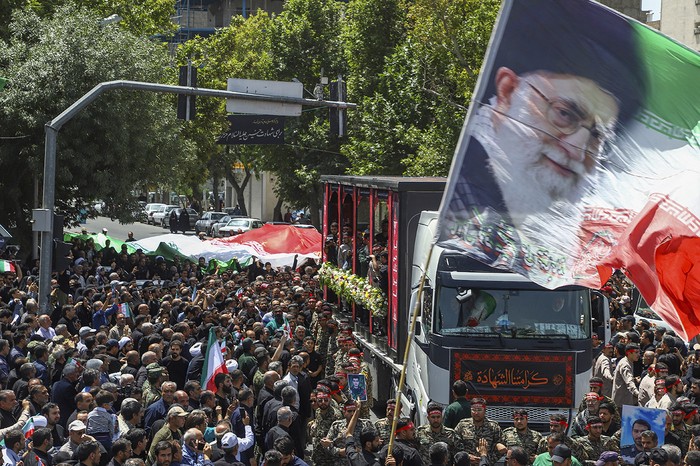 Bandera con el retrato del líder supremo iraní, el ayatolá Alí Jamenei, durante la procesión fúnebre de 15 personas muertas en los ataques israelíes, en la ciudad de Mashhad. · Foto: Sadegh Hatami, ISNA, AFP