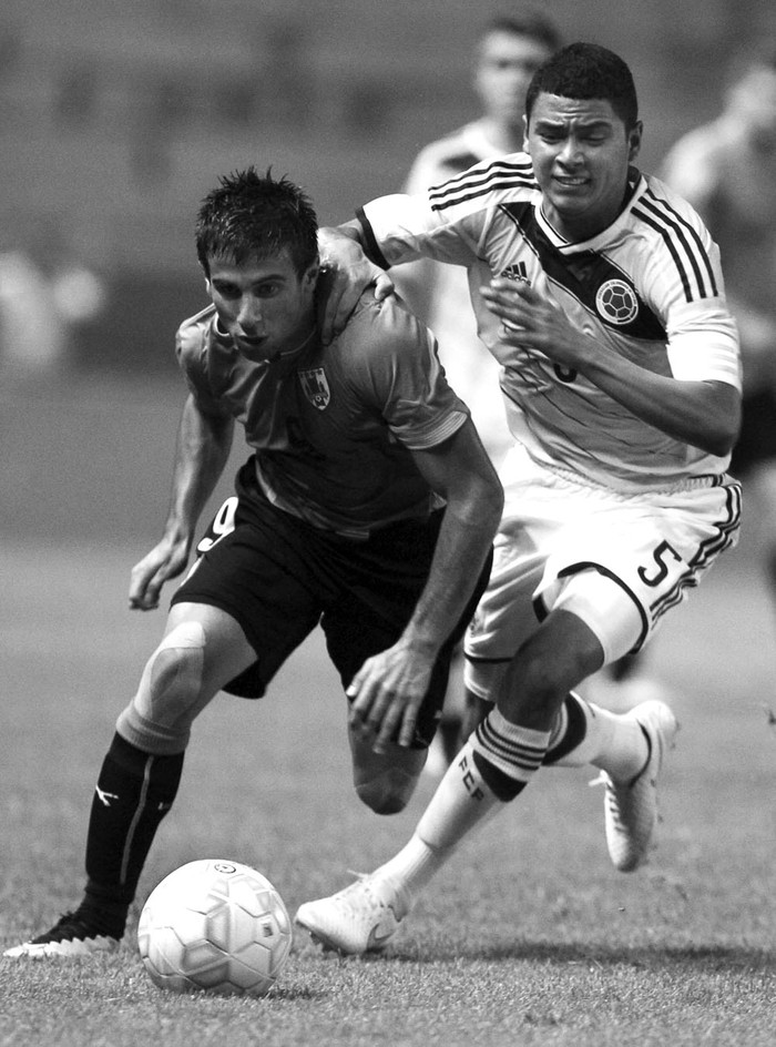 Diego Rossi, de Uruguay, y Stiven Londoño, de Colombia, el viernes 20, en el estadio Nicolás Leoz de Asunción (Paraguay), durante el Sudamericano sub 17. Foto: Andrés Cristaldo, Efe